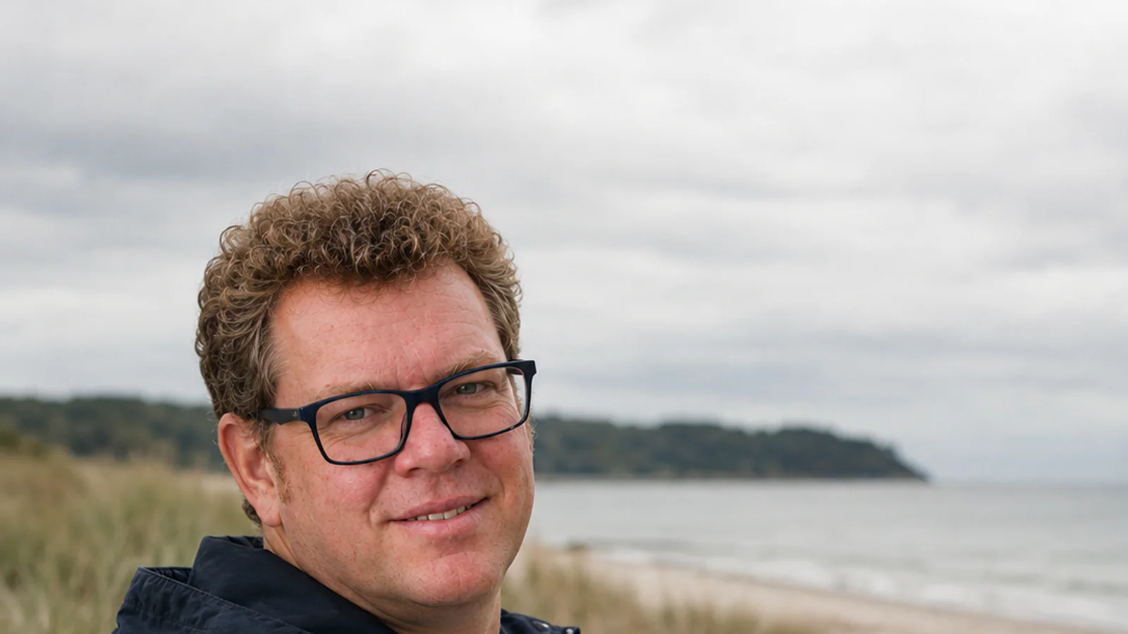 Christian Rüsken on the beach, looking out at the sea and horizon